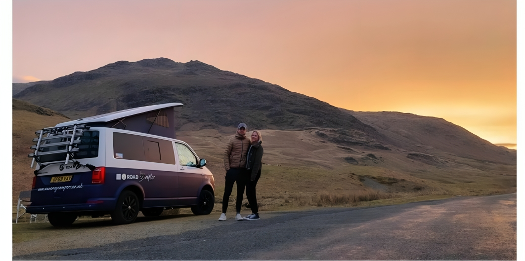 couple posing outside a waveney camper van on their holiday